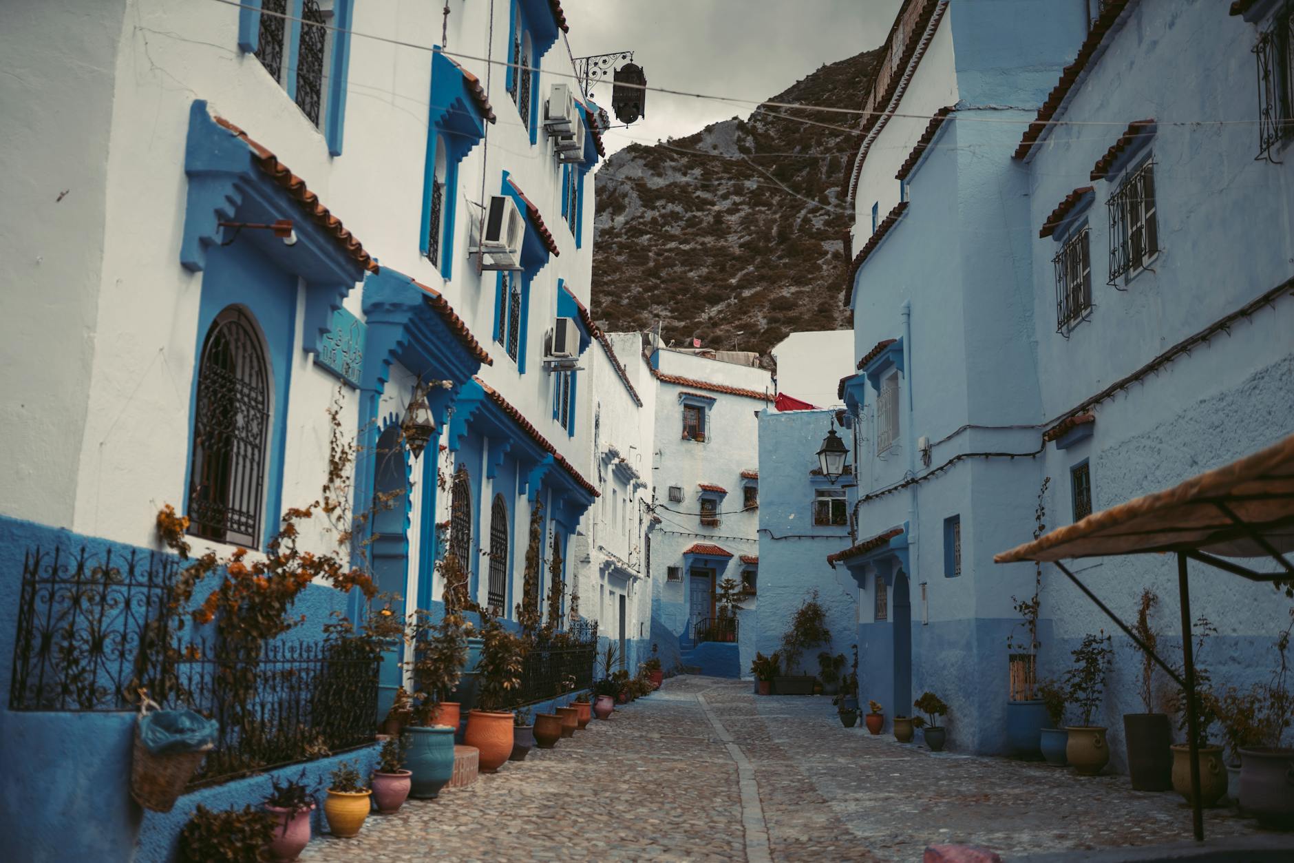 Explore the iconic blue alleyways and potted plants of Chefchaouen, Morocco's blue city.